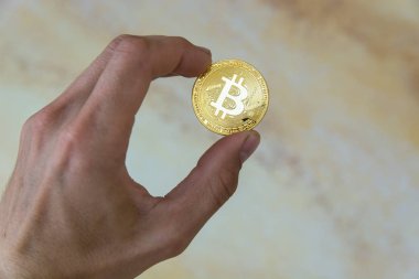 adamın elinde altın bitcoin