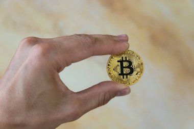 adamın elinde altın bitcoin