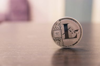 Ahşap masa üzerinde gümüş Litecoin duruyor