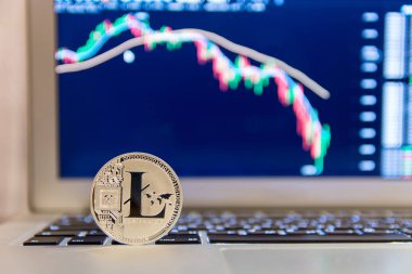 Grafik azalan ile defter keydoard üzerinde gümüş Litecoin