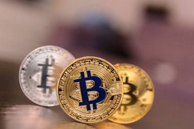  ahşap masa üzerinde altın ve gümüş bitcoins