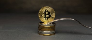  Altın bitcoin gümüş çatal ile sikke yığını üzerinde durmak