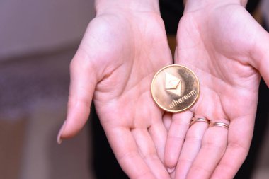 güzel bir sarışın kızın elinde altın ethereum 