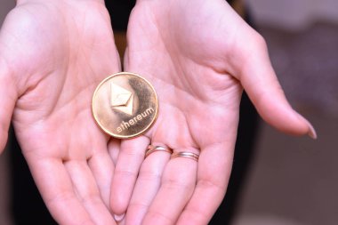 güzel bir sarışın kızın elinde altın ethereum 