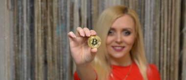 güzel bir sarışın kızın elinde altın bitcoin 