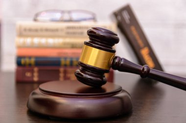 Yargıç tokmak yanında yığın kitap ahşap arka plan üzerinde