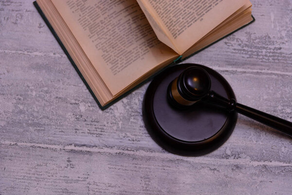 judge gavel beside pile of books on wooden background