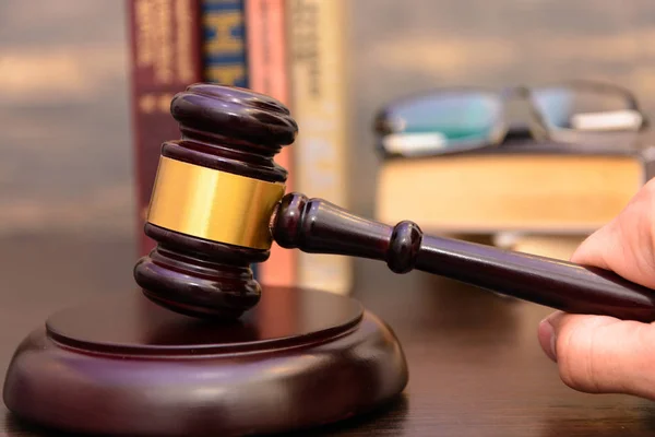 judge gavel beside pile of books on wooden background