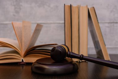 Yargıç tokmak yanında yığın kitap ahşap arka plan üzerinde