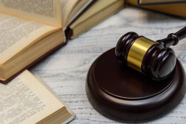 Yargıç tokmak yanında yığın kitap ahşap arka plan üzerinde