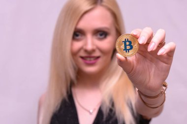 güzel bir sarışın kızın elinde altın bitcoin 