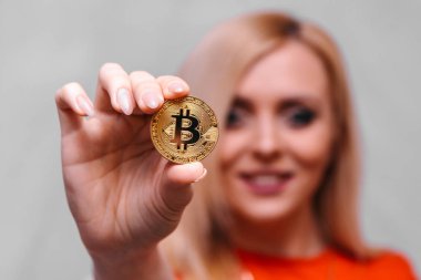 güzel bir sarışın kızın elinde altın bitcoin 