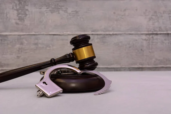 Recht und Bösartigkeit. Hammer eines Richters und Handschellen auf weißem Hintergrund — Stockbild Recht Und Bösartigkeit Hammer Eines Richters Und Handschellen Auf Weißem — Stockfoto