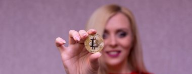 güzel bir sarışın kızın elinde altın bitcoin 
