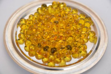 Balık yağı hap metal bir plaka üzerinde