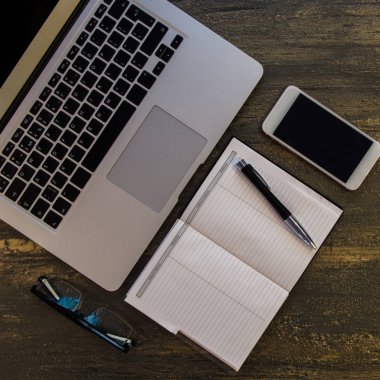 Metin kopyalama yeri olan eski bronz arka plan üzerinde tablo ya da dizüstü bilgisayar, boş defter, kalem ve akıllı telefon Danışma üstten görünüm.