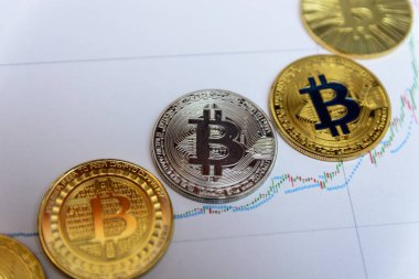Altın bitcoin yalan kağıt grafik üzerinde artan grafik şeklinde