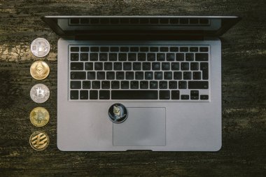 Metin kopyalama yeri olan eski bronz arka plan üzerinde tablo ya da dizüstü bilgisayar, bitcoins litecoins ve ethereum Resepsiyon üstten görünüm.