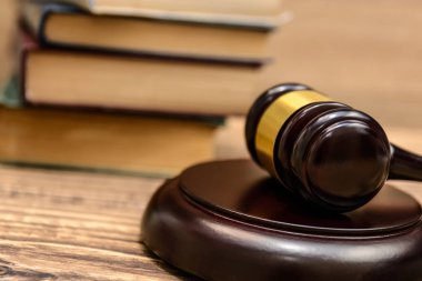 Yargıç tokmak yanında yığın kitap ahşap arka plan üzerinde
