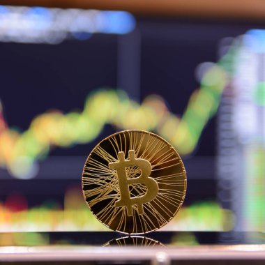 Altın bitcoin ve grafik monitör