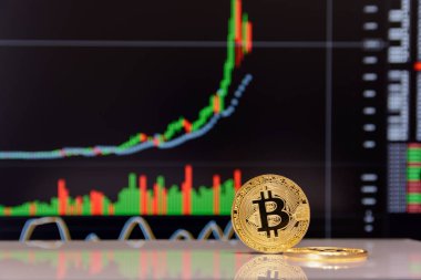 Altın bitcoin ve grafik monitör