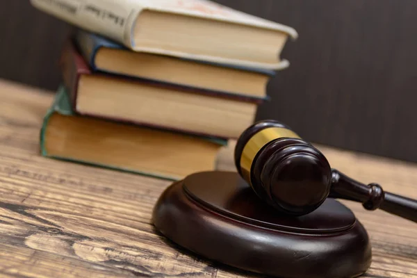 judge gavel beside pile of books on wooden background