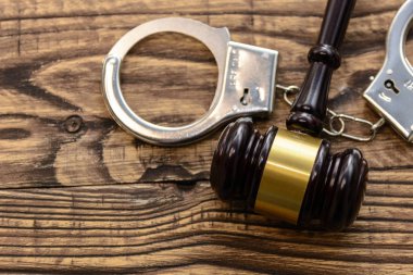 Hukuk ve gustice. Bir yargıç ve kelepçe ahşap arka plan üzerinde çekiç