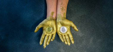 Gümüş ve altın bitcoin yalan üzerine altın boya ile boyanmış iki kadının avuç içi,