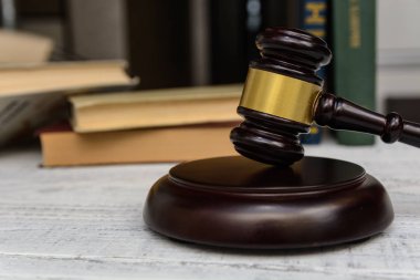 Yargıç tokmak yanında yığın kitap ahşap arka plan üzerinde