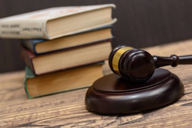 Yargıç tokmak yanında yığın kitap ahşap arka plan üzerinde