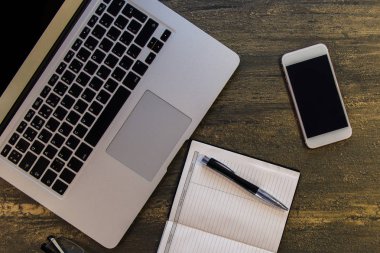 Metin kopyalama yeri olan eski bronz arka plan üzerinde tablo ya da dizüstü bilgisayar, boş defter, kalem, gözlük ve akıllı telefon Danışma üstten görünüm.