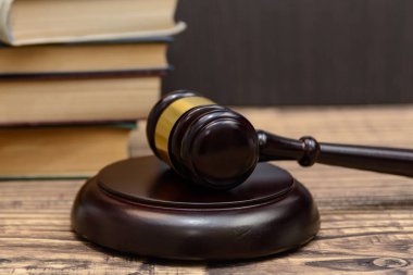 Yargıç tokmak yanında yığın kitap ahşap arka plan üzerinde