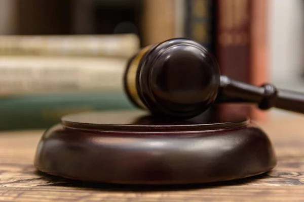 judge gavel beside pile of books on wooden background