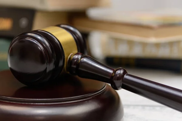 judge gavel beside pile of books on wooden background