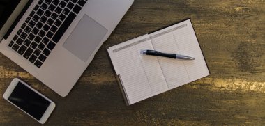 Metin kopyalama yeri olan eski bronz arka plan üzerinde tablo ya da dizüstü bilgisayar, boş defter, kalem ve akıllı telefon Danışma üstten görünüm.