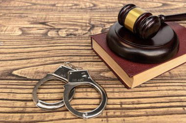 Hukuk ve gustice. Bir yargıç ve kelepçe ahşap arka plan üzerinde çekiç