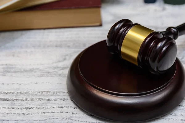 judge gavel beside pile of books on wooden background