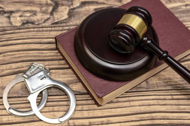 Hukuk ve gustice. Bir yargıç ve kelepçe ahşap arka plan üzerinde çekiç