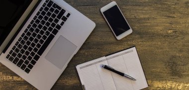 Metin kopyalama yeri olan eski bronz arka plan üzerinde tablo ya da dizüstü bilgisayar, boş defter, kalem ve akıllı telefon Danışma üstten görünüm.