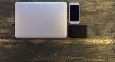 Metin kopyalama yeri olan eski bronz arka plan üzerinde tablo ya da dizüstü bilgisayar, siyah sabit disk ve akıllı telefon Danışma üstten görünüm.