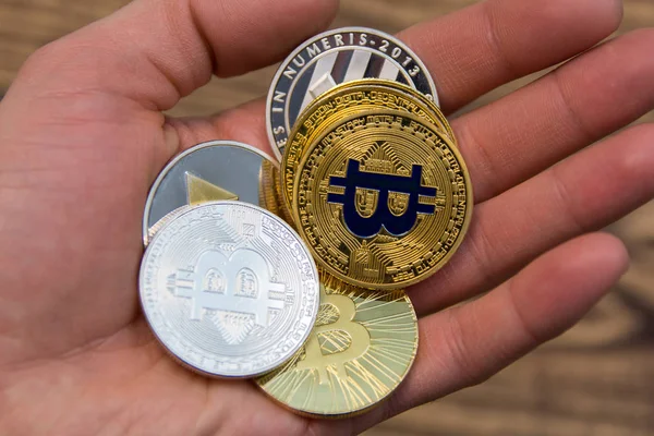  Bitcoins, litecoin ve ethereum eski ahşap zemin üzerine adamın elinde