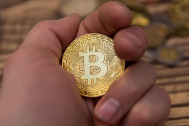  Adamın parmakları eski ahşap arka plan üzerinde tutan bitcoin