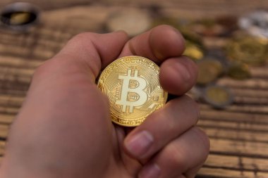  Adamın parmakları eski ahşap arka plan üzerinde tutan bitcoin
