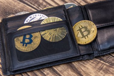  bitcoins, litecoin ve ethereum siyah deri cüzdan eski ahşap masa