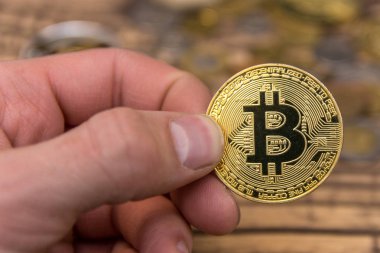  Adamın parmakları eski ahşap arka plan üzerinde tutan bitcoin