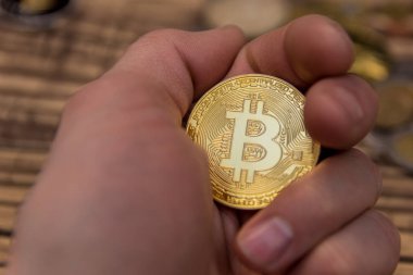  Adamın parmakları eski ahşap arka plan üzerinde tutan bitcoin