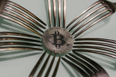 Gümüş bitcoin ve çevresindeki gümüş çatal