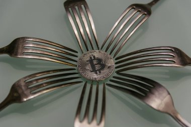 Gümüş bitcoin ve çevresindeki gümüş çatal