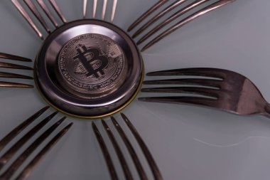  Gümüş çatal ile gümüş matall daire üzerinde gümüş bitcoin
