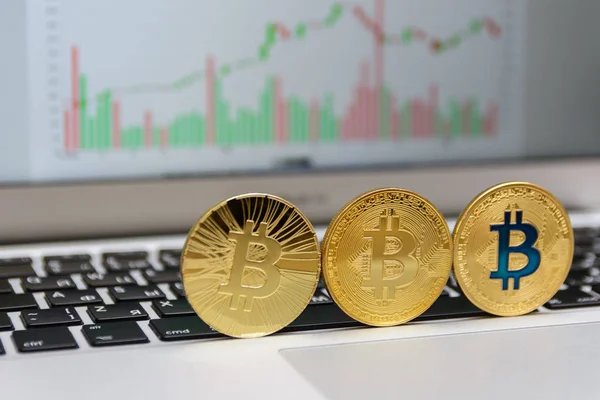 Altın bitcoins klavye ve grafik arka plan üzerinde durmak